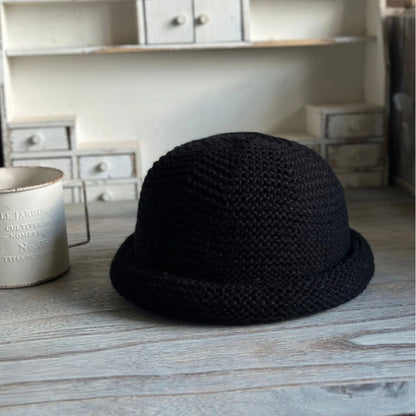 Front view of a black wool blend knit beanie with a sculpted dome crown and compact rolled brim