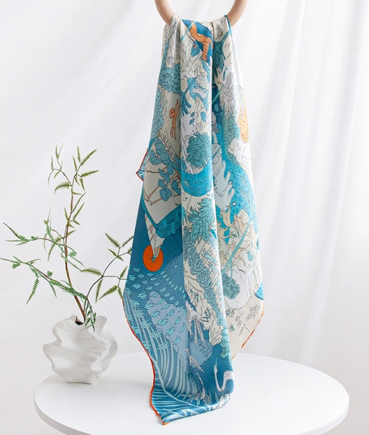 100% mulberry silk square scarf styled with blue wildlife artwork for elegant everyday accessory looks.
