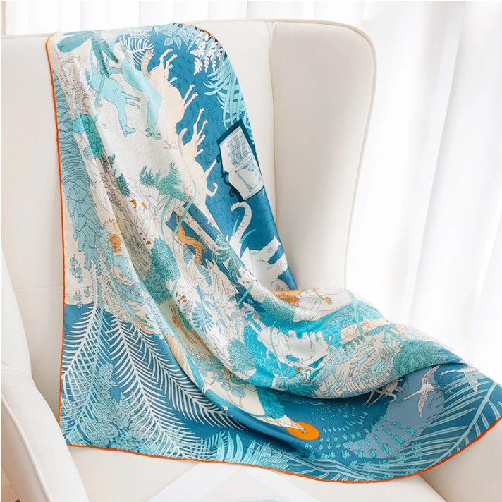 Blue animalier silk scarf draped on a chair, featuring a glossy large square scarf design.