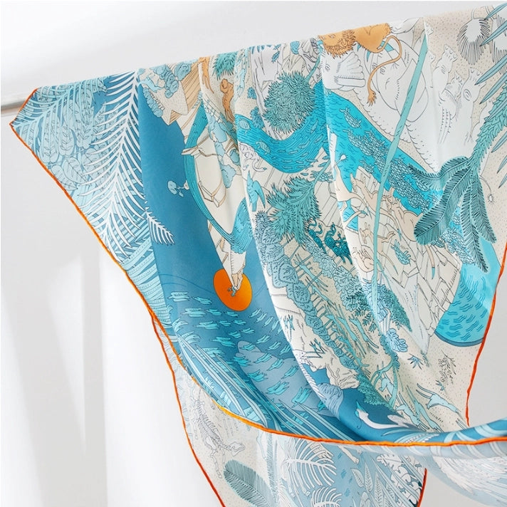 Close-up of blue animal kingdom silk scarf with exotic wildlife print and soft drapable silk finish.