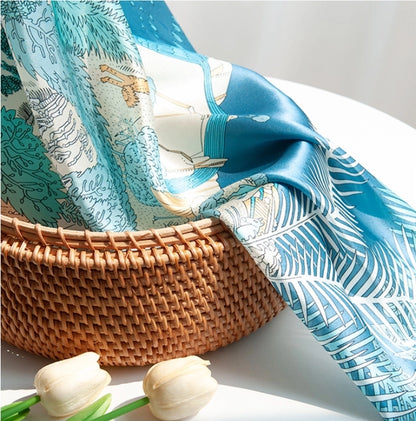 Blue wildlife print silk scarf styled on a woven basket for elegant fashion and bag accessory display.