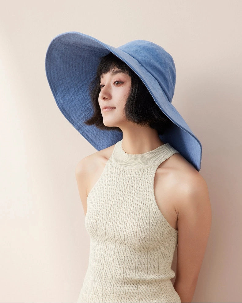 Side view of blue cotton wide brim sun hat with oversized floppy brim for summer styling