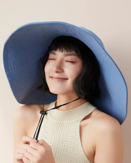 Close-up of blue cotton oversized sun hat with wind cord and full coverage floppy brim