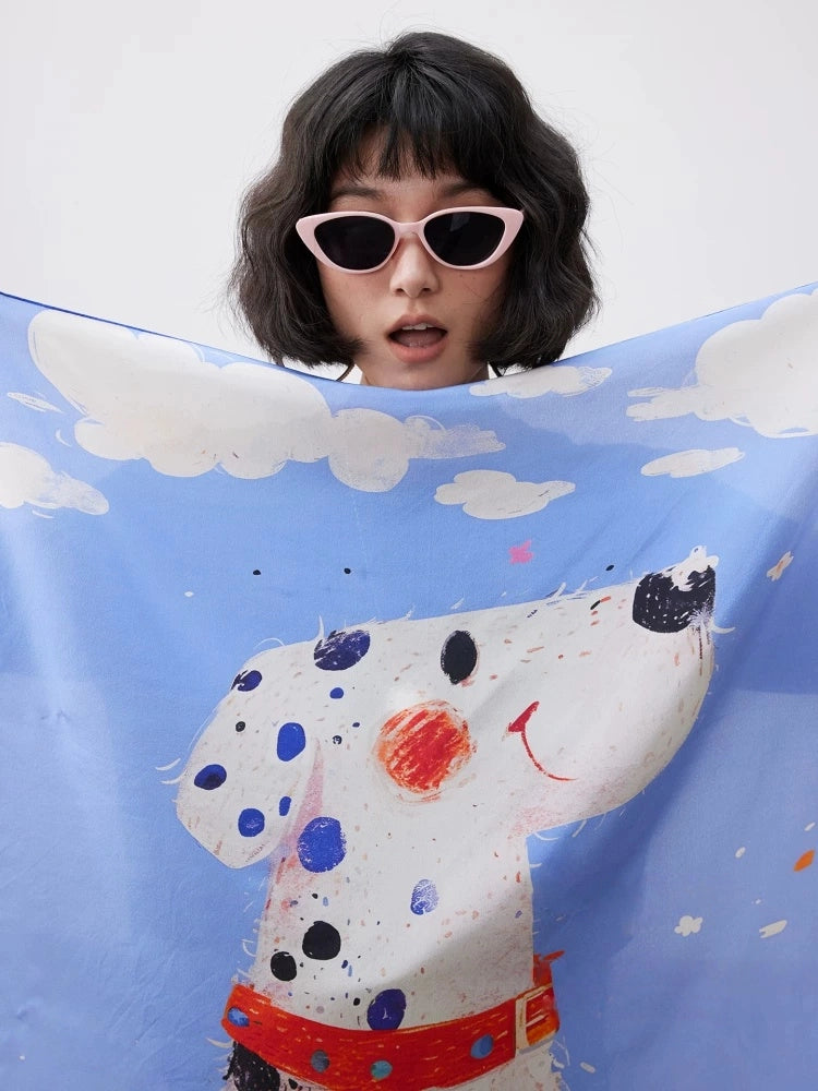 Close-up of blue dalmatian printed silk square scarf with cloud details and artistic dog design