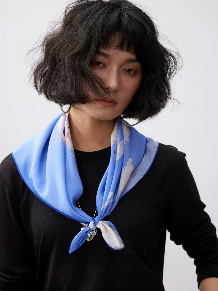 Blue animal print silk square scarf tied as a chic neck scarf for casual everyday styling