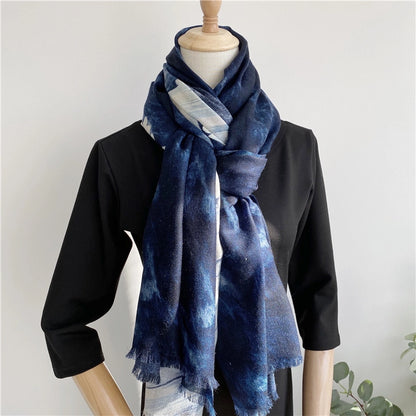 Blue galaxy wool scarf styled in a long knotted drape over a black dress on a mannequin