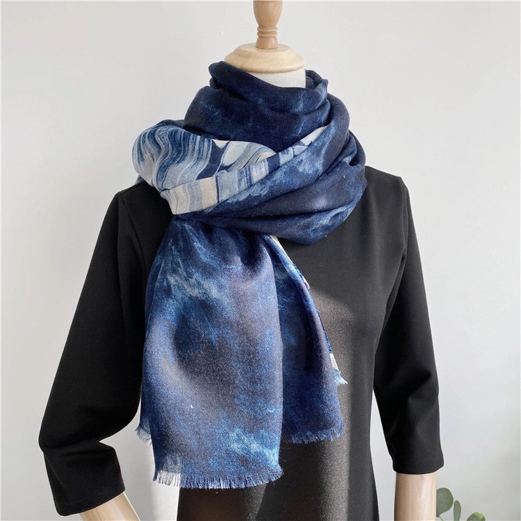 Oversized blue galaxy wool shawl arranged in a voluminous layered wrap over a black outfit