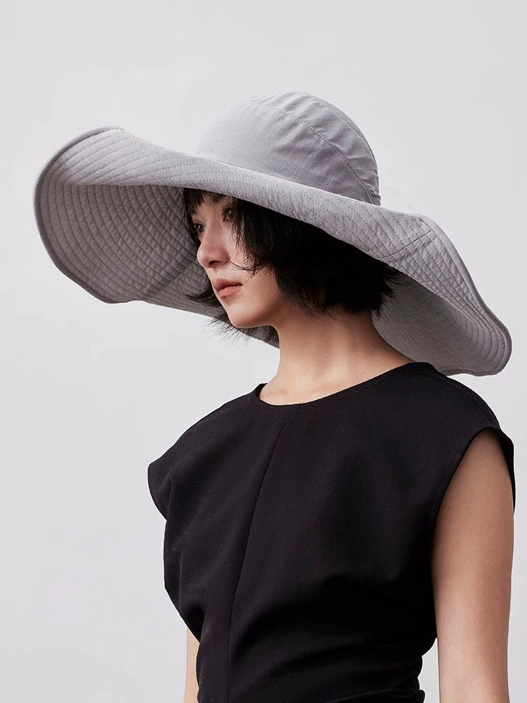 Model wearing blue gray wide brim sun hat with UPF 100 UV protection and elegant summer style