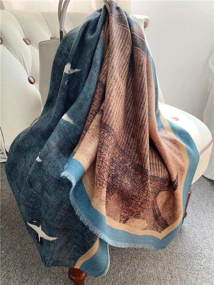 Blue and brown Oriental crane wool scarf draped over a chair, showing the pavilion border
