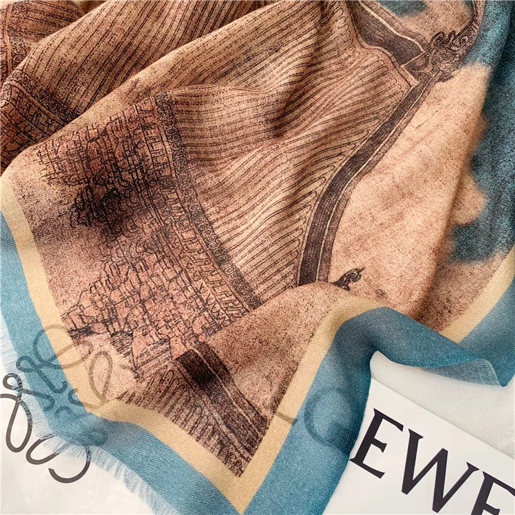 Close-up of the fine wool scarf drape featuring vintage pavilion artwork in blue and brown