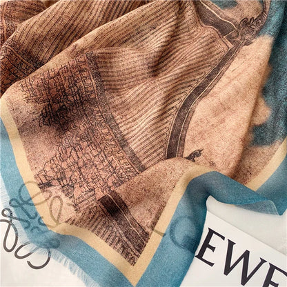 Close-up of the fine wool scarf drape featuring vintage pavilion artwork in blue and brown