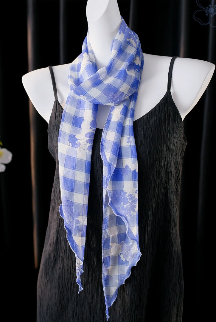 Blue white plaid mulberry silk skinny scarf draped on a mannequin, showing its lightweight and flowing shape.