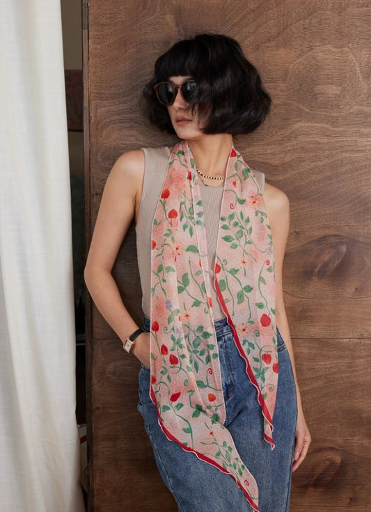 Long blush pink botanical silk scarf worn with sleeveless top and jeans