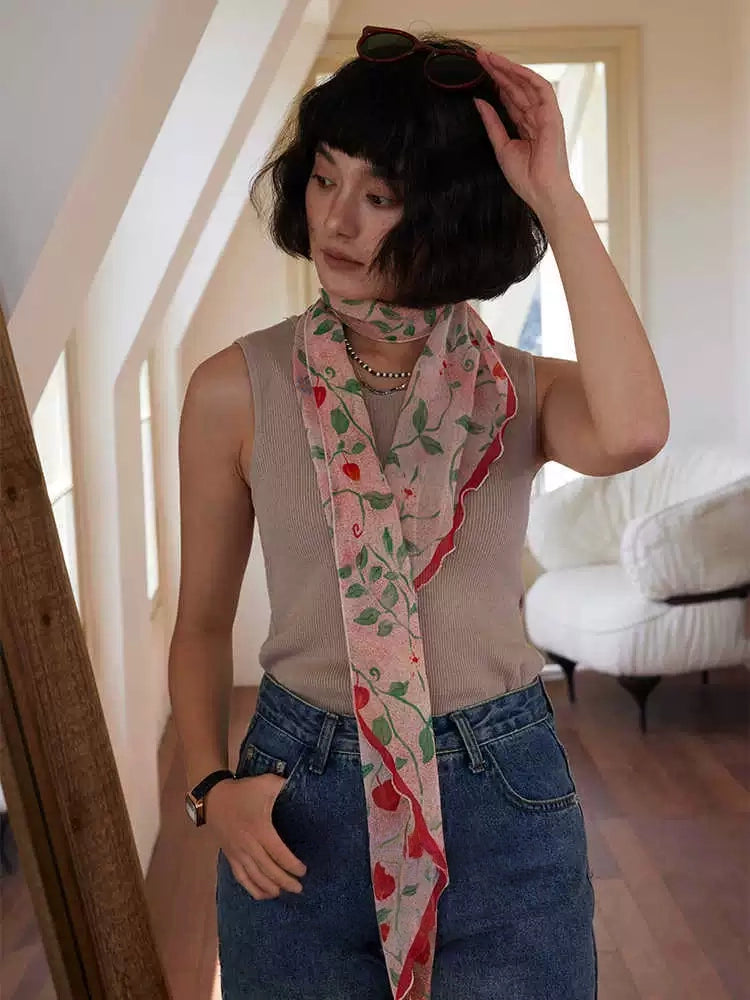 Romantic botanical long silk scarf styled loosely over a neutral sleeveless top