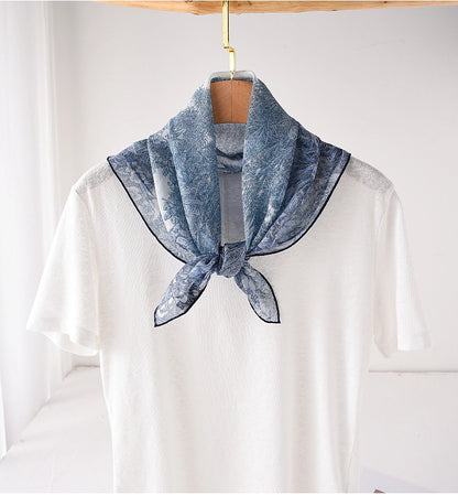 Blue botanical silk square scarf tied at the neck with a refined feminine look