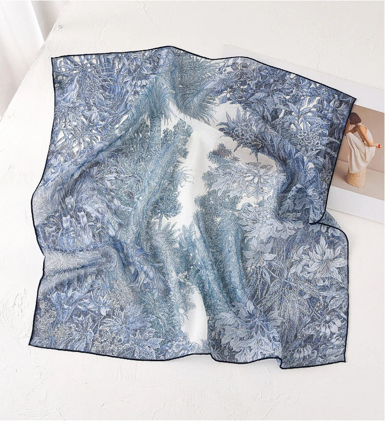 Blue botanical print mulberry silk square scarf displayed flat to show sheer texture