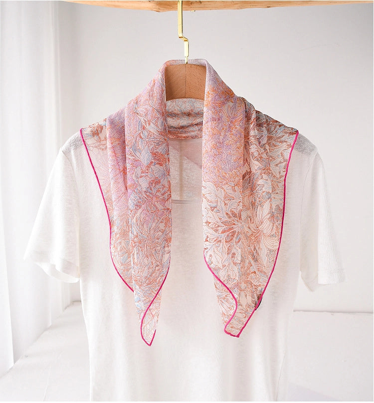 Pink botanical mulberry silk neck scarf draped over a white top for soft elegant styling
