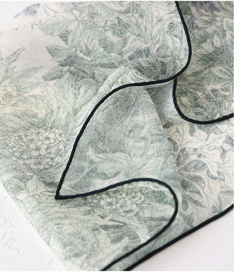 Close-up of deep green mulberry silk scarf with botanical pattern and delicate edging