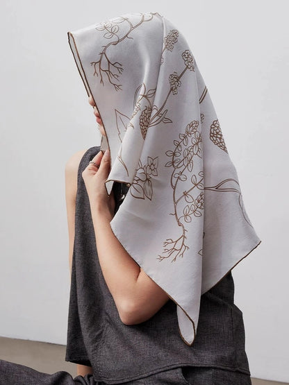Botanical floral silk square scarf worn as a headscarf, featuring soft neutral tones and elegant mulberry silk texture