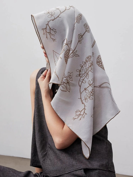 Botanical floral silk square scarf worn as a headscarf, featuring soft neutral tones and elegant mulberry silk texture