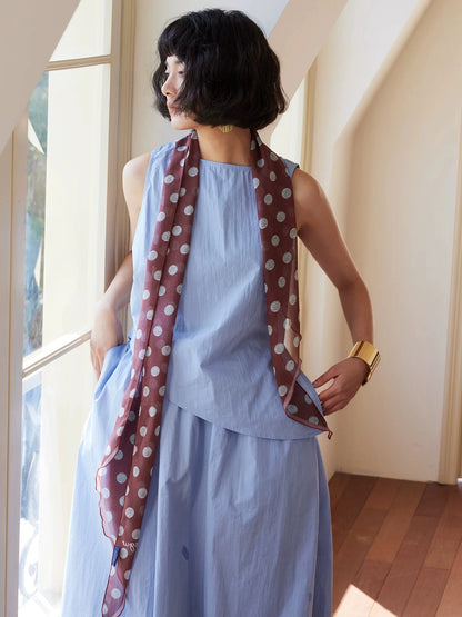 Brown polka dot mulberry silk twilly scarf worn as a long ribbon scarf for elegant summer styling