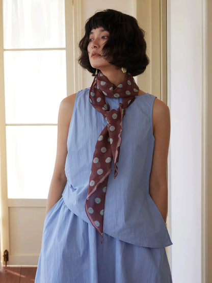 Brown polka dot long silk twilly scarf styled with sleeveless blue dress for classic everyday wear