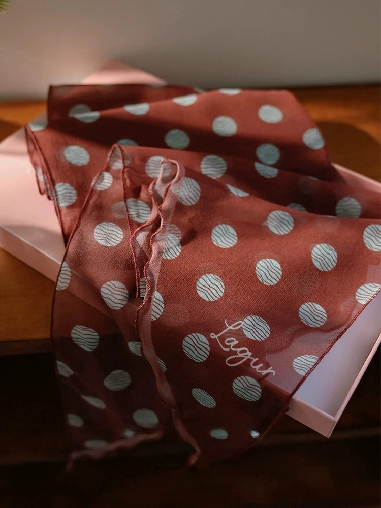 Close-up of brown polka dot 100% mulberry silk georgette scarf with soft semi-sheer texture