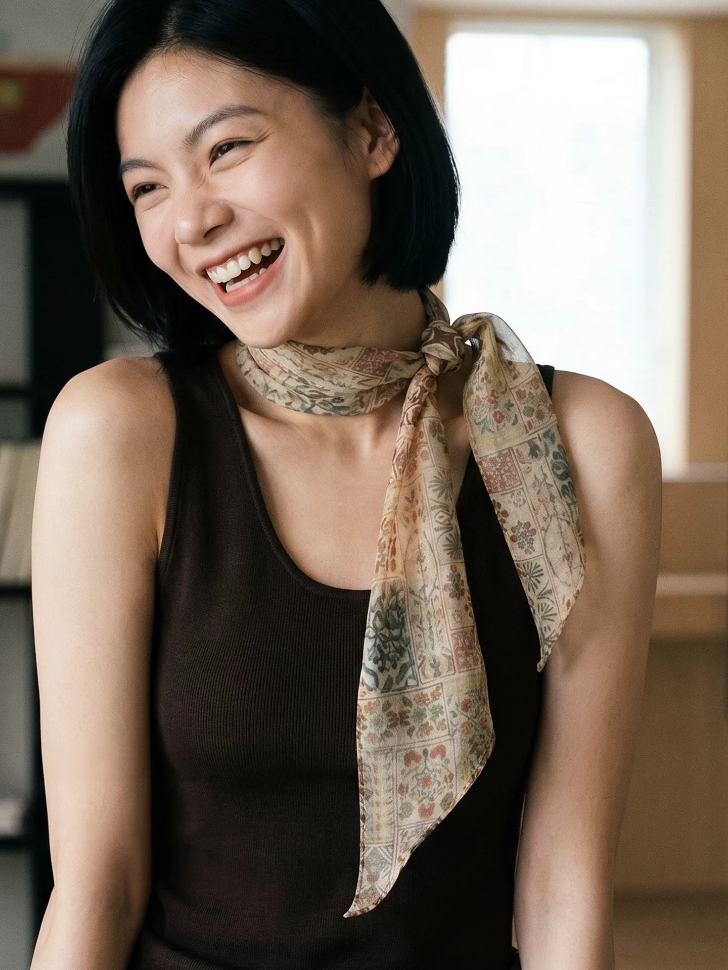 Woman styling a long brown vintage floral silk scarf in a relaxed side knot with a sleeveless brown top