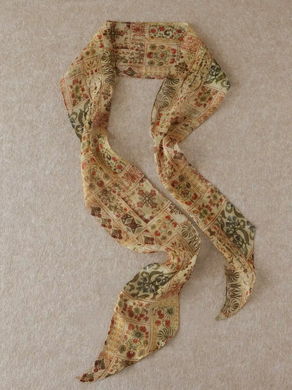Long brown floral mulberry silk ribbon scarf displayed in a flowing S shape on a neutral beige background