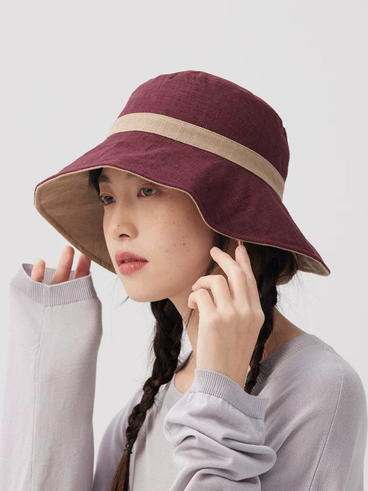 Side view of a burgundy embroidered bucket hat with beige contrast trim