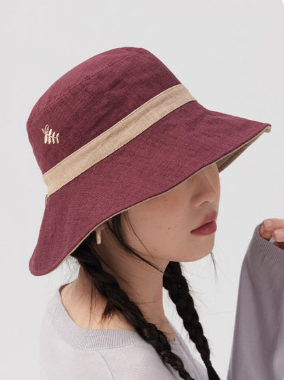 Close-up of a burgundy beige foldable bucket hat with delicate embroidery and curved brim