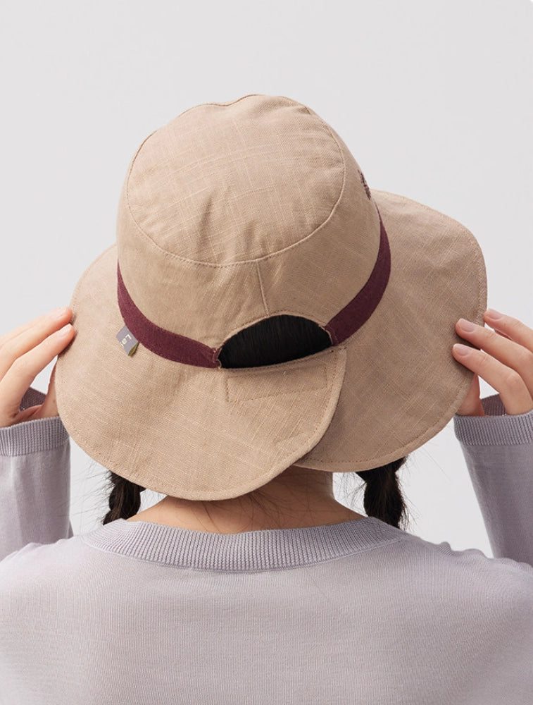 Back view of a beige reversible ramie cotton bucket hat with burgundy trim and adjustable strap