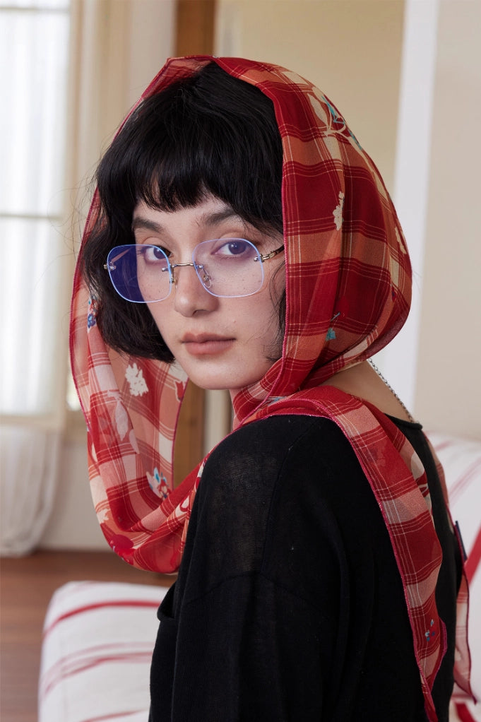 Cherry plaid skinny silk scarf worn as a silk headscarf, showing burgundy tartan pattern and elegant drape