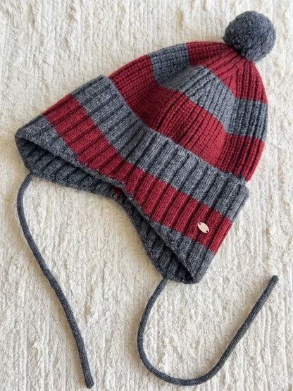 Burgundy and charcoal grey striped wool earflap beanie laid flat, showing the grey pom pom and matching ties.