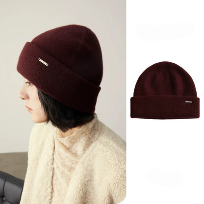 Woman wearing a burgundy pure cashmere cuffed beanie with a matching product view