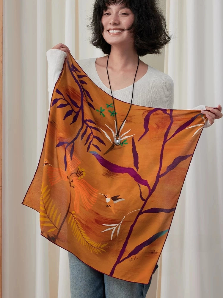 Woman displaying a burnt orange abstract botanical silk square scarf over a white top
