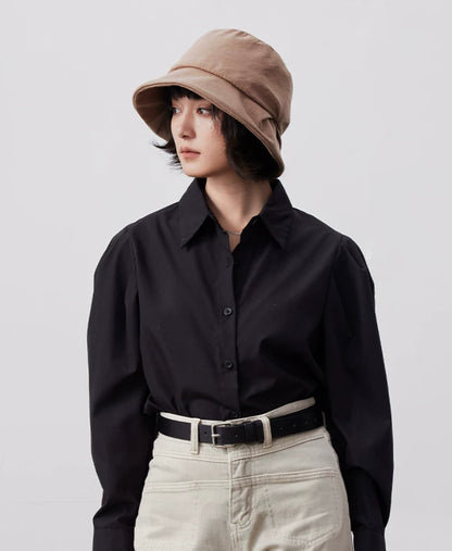 Model wearing a camel artistic pleated bucket hat with a black shirt and cream trousers