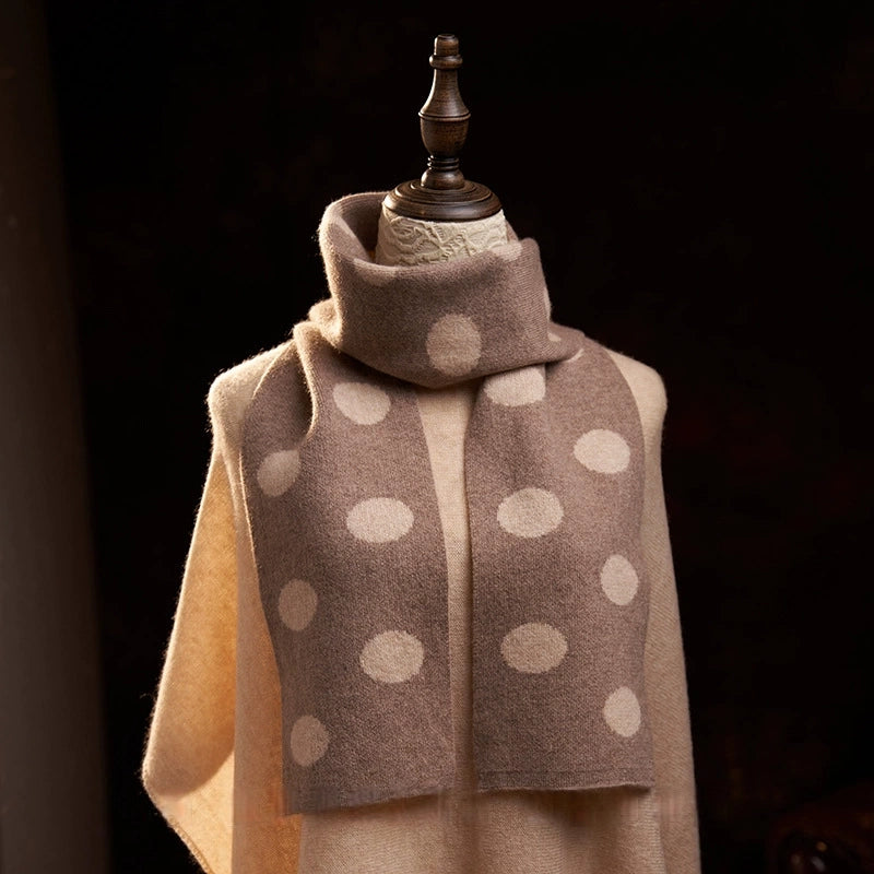 Camel cashmere scarf with cream polka dots wrapped around the neck, with both ends draped down the front.