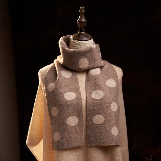 Camel cashmere scarf with cream polka dots wrapped around the neck, with both ends draped down the front.