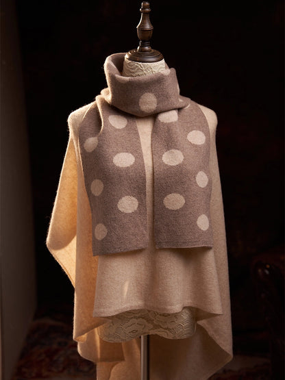 Front view of a camel polka dot cashmere scarf displayed on a mannequin over a camel sweater.
