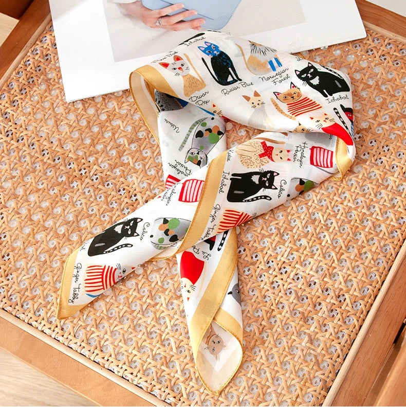 Cat print silk scarf in 100% mulberry silk, displayed with soft folds and an elegant ivory border.