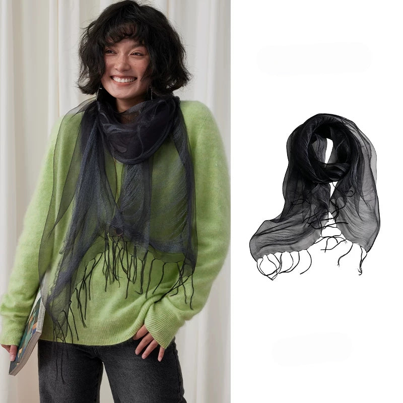 Woman wearing a charcoal gray sheer mulberry silk fringe scarf over a green sweater