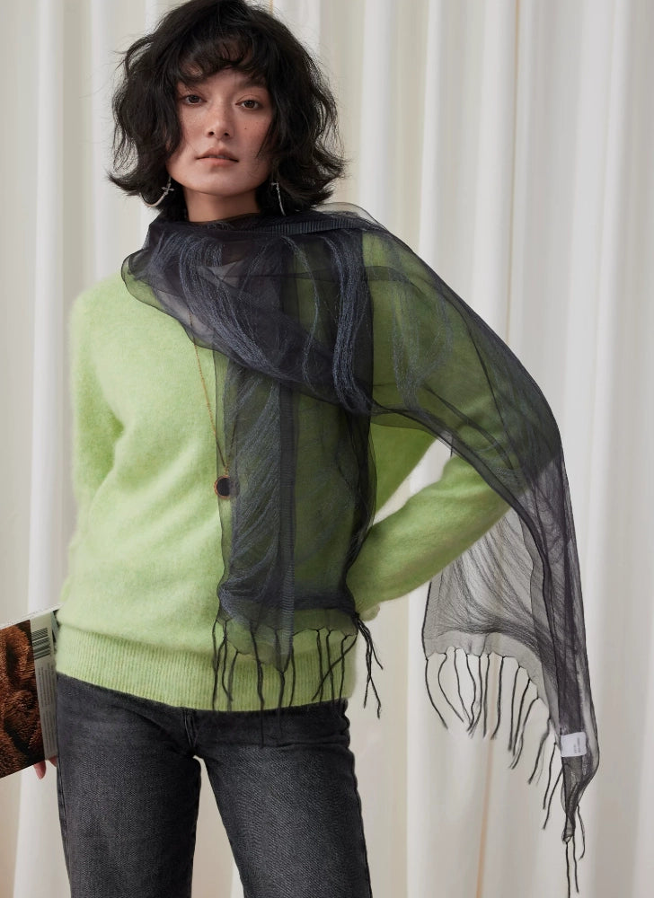 Woman styling a sheer charcoal gray silk scarf as an elegant shoulder wrap