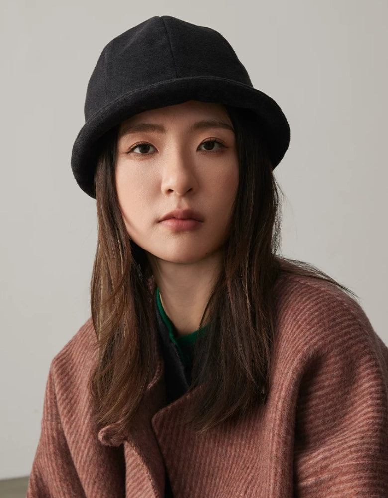 Woman wearing a charcoal gray felt cloche hat with a rolled brim and vintage round crown
