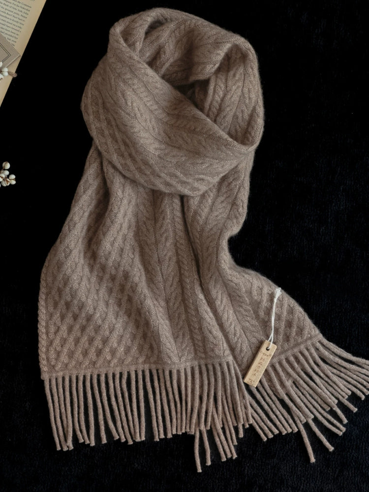 Coffee brown cable knit scarf loosely knotted on a black background, showing its textured knit and fringed ends.
