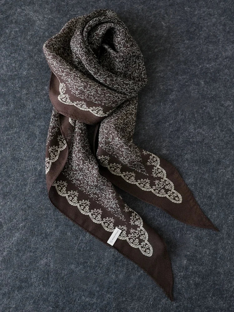 Coffee brown vintage floral silk wool scarf arranged on a dark textured background