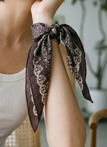Coffee brown floral silk wool scarf tied around the wrist as an elegant accessory