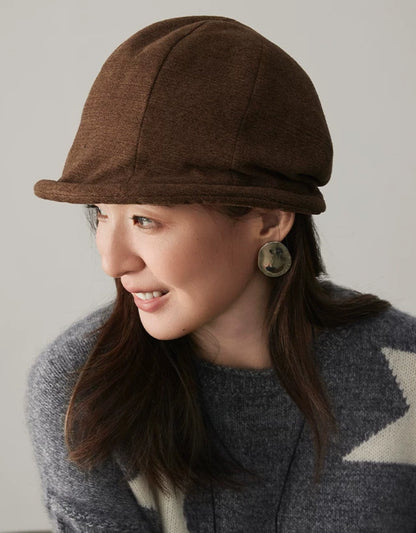 Side view of a coffee brown vintage dome hat with a sculpted crown and narrow rolled brim