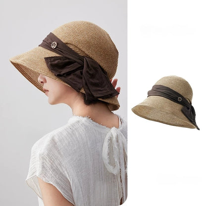 Coffee wide brim straw sun hat with bow ribbon detail and windproof cord, shown in a side-back summer styling view.
