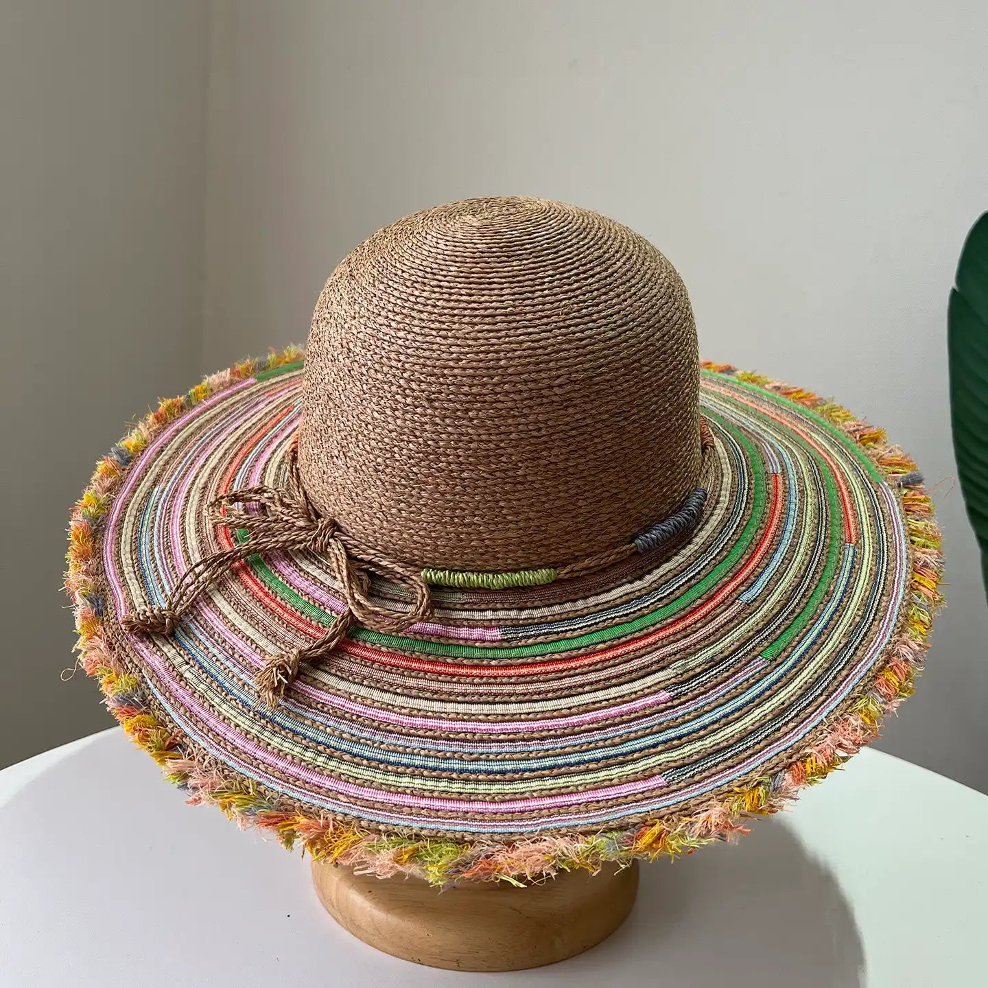 Brown raffia straw beach hat with multicolor woven brim and natural tie detail.